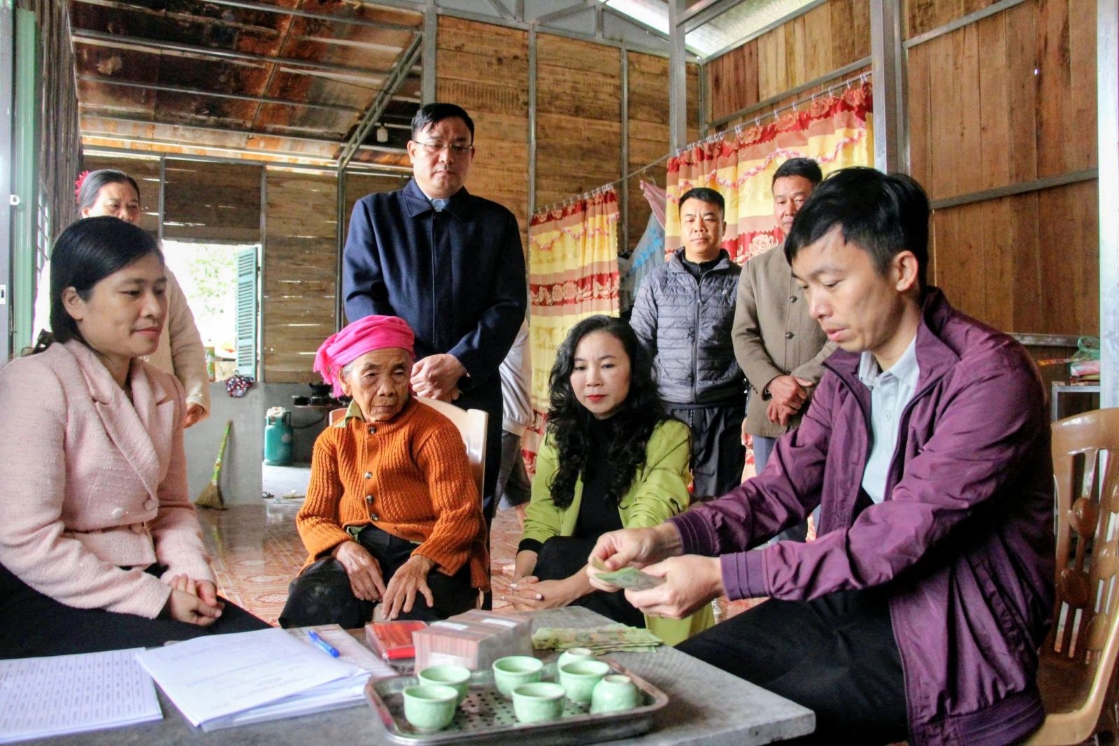 Cán bộ chuyên môn trao tiền hỗ trợ cho hộ gia đình